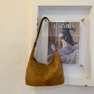 Dettaglio della borsa tote vintage in pelle scamosciata marrone con texture opaca morbida