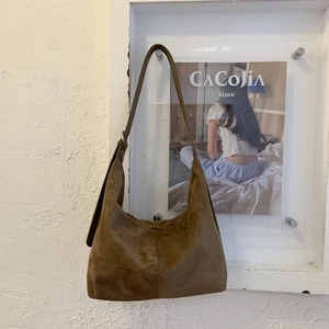 Macro di una borsa hobo in pelle smerigliata marrone scuro con cerniera e fibbia metallica