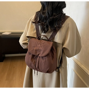 Detail of coffee brown drawstring backpack with waffle texture and YOU JIBEAR embroidery