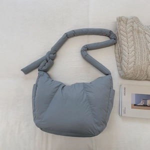 Dettaglio della borsa a nuvola trapuntata blu con trama imbottita e tracolla a nodo