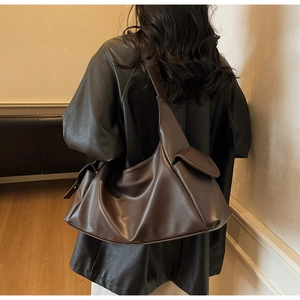 Détail d'un grand sac bandoulière marron café avec poches latérales à rabat sur mannequin