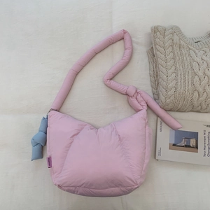 Borsa a spalla trapuntata rosa con ciondolo a nodo blu e dettaglio texture morbida