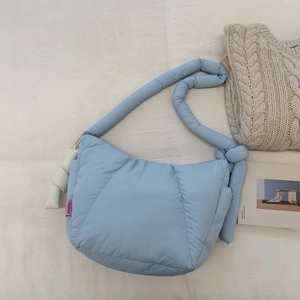 Dettaglio della borsa a bolle trapuntata celeste con etichetta tessuta e ciondolo a corda