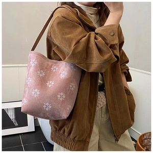 Dettaglio della borsa tote in pelle scamosciata rosa con ricami a fiocco di neve bianchi