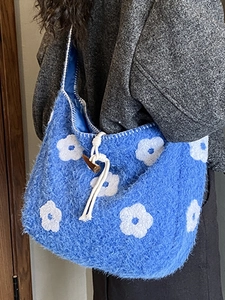 Blue plush tote bag with white flower embroidery and wooden toggle button closure