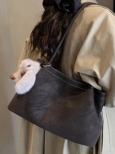 Minimalistische große Tragetasche in Dunkelbraun mit Kontrastnähten und Plüsch-Hasen-Anhänger