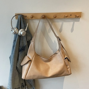 Détail du sac hobo en similicuir abricot avec poches latérales et bandoulière large