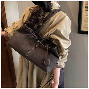 Close-up of vintage dark brown tote bag with premium synthetic leather texture and straps