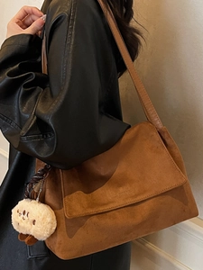 Minimalist caramel brown shoulder bag with chain strap and cute plush biscuit charm