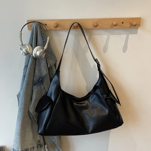Détail du grand sac porté épaule demi-lune en cuir noir avec poches latérales à rabat