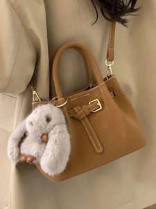 Brown frosted underarm tote bag with white stitching and plush bunny pendant