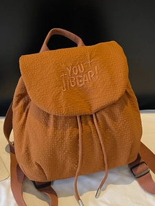 Brown textured backpack with drawstring closure and letter embroidery for outdoor use