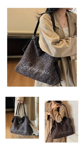 Close-up of leopard print tote bag featuring black leather trim and white script embroidery