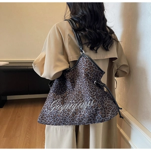 Detail of leopard print hobo tote bag featuring custom white embroidery on the front