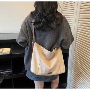 Close-up of off-white faux suede tote bag showing large capacity and soft texture
