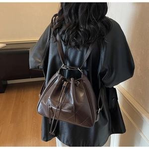 Detail of vintage brown quilted faux leather tote bag with drawstring and zip pocket