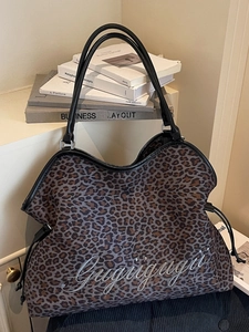 Minimalist leopard print tote bag with black leather handles and drawstring side details