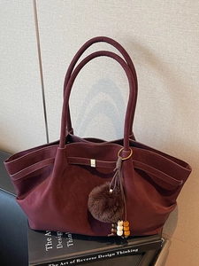 Deep burgundy faux suede tote bag with fur pompom charm and beads on design books