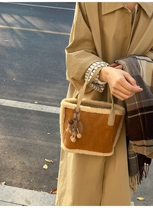 Sac fourre-tout en daim marron avec bordure pelucheuse porté par un mannequin