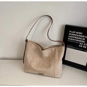 Detail shot of the beige suede tote bag featuring high-quality texture and brown leather strap