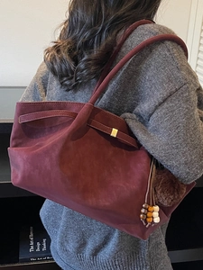 Retro burgundy suede tote bag with decorative tassel and beads in a cozy casual style