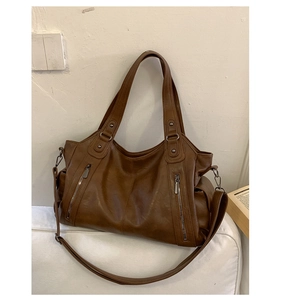 Vue détaillée du sac cabas marron vintage montrant la texture, la poche et les fermetures