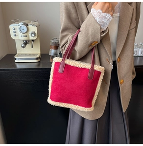 Détail du sac seau en daim rouge avec bordure en laine de mouton et poignées en cuir