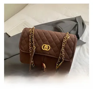 Gros plan détaillé d'un sac cabas marron matelassé avec chaîne dorée et fermoir en métal