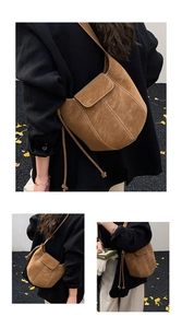 Detail of brown suede bucket bag with decorative stitching and long cord drawstring
