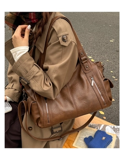 Détail d'un sac cabas marron vintage en cuir PU avec fermetures éclair et texture fine