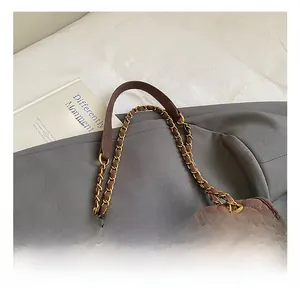 Vue macro détaillée de la poignée et de la chaîne dorée du sac cabas matelassé marron