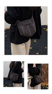 Detail of dark frosted suede bucket bag with contrast stitching and adjustable strap
