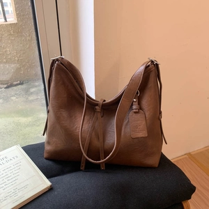Détail d'un sac cabas rétro en cuir marron avec bandoulière réglable et boucle en métal
