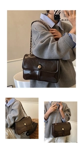 Detail of dark brown glossy leather crossbody bag with gold chain strap and turn-lock