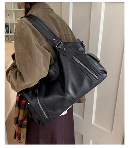 Détail du sac cabas noir en cuir PU avec fermetures éclair et rivets sur la bandoulière