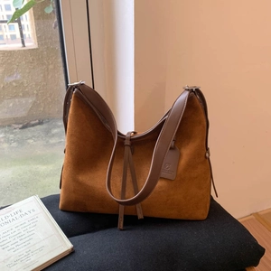 Vue macro détaillée de la texture suédée marron et des lanières en cuir de ce sac cabas
