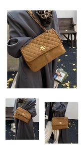 Détail d'un sac cabas en daim marron matelassé avec chaîne dorée et fermoir en métal rond
