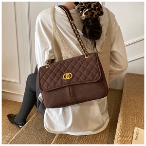 Détail d'un cabas vintage en daim marron avec matelassage en losange et boucle dorée