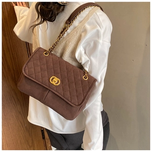 Détail du sac bandoulière matelassé marron foncé avec fermoir doré et bandoulière chaîne