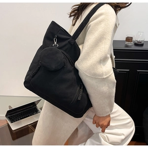 Dettaglio borsa tote in velluto a coste nero con piccolo portamonete per il lavoro