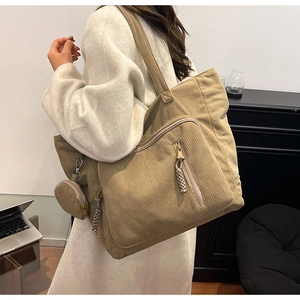 Dettaglio della borsa tote in velluto kaki con tasca a zip e mini portamonete rotondo