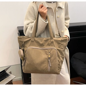 Dettaglio della borsa tote in velluto a coste kaki con trama a righe e portamonete extra