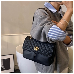 Détail du sac bandoulière matelassé noir avec chaîne dorée et fermoir pivotant chic
