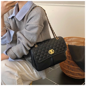 Gros plan du sac cabas en cuir matelassé noir avec boucle dorée et bandoulière