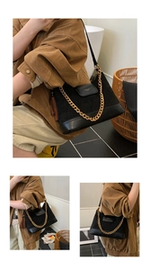 Close-up of suede shoulder bag with diamond quilting and decorative gold chain strap