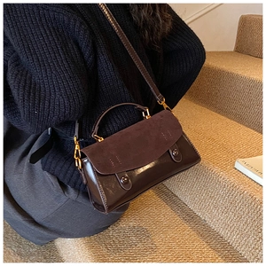 Dettaglio della borsa a tracolla in pelle marrone scuro con patchwork in camoscio