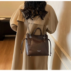 Dettaglio borsa tote in pelle cerata marrone scuro con catena argento e coulisse