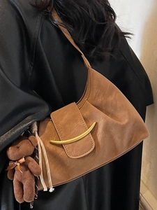 Minimalist brown vintage underarm shoulder bag with gold hardware and plush bear charm