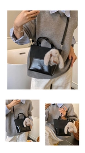 Detail of black patchwork tote bag with fashion lettering and cute plush rabbit charm