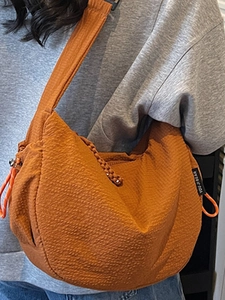 Borsa a tracolla a mezzaluna stile giapponese color caramello con superficie testurizzata